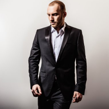 Zarif genç gülümseyen yakışıklı siyah kostüm. Studio moda portre.