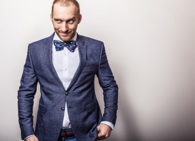 Zarif genç yakışıklı adam koyu mavi kostüm ve papyon. Studio moda portre.