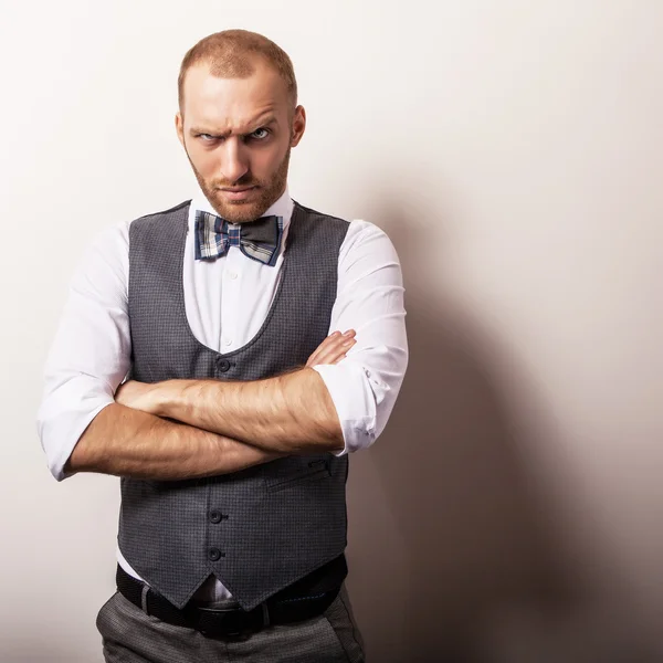 Eleganter junger gutaussehender Mann im grauen Kostüm. Modeporträt im Studio. — Stockfoto