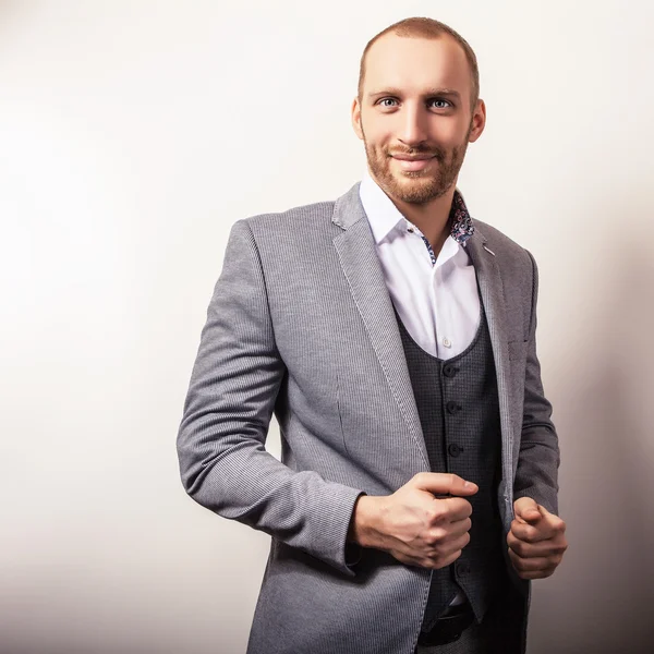 Elegante jovem e bonito homem de fato cinzento. Estúdio retrato de moda . — Fotografia de Stock