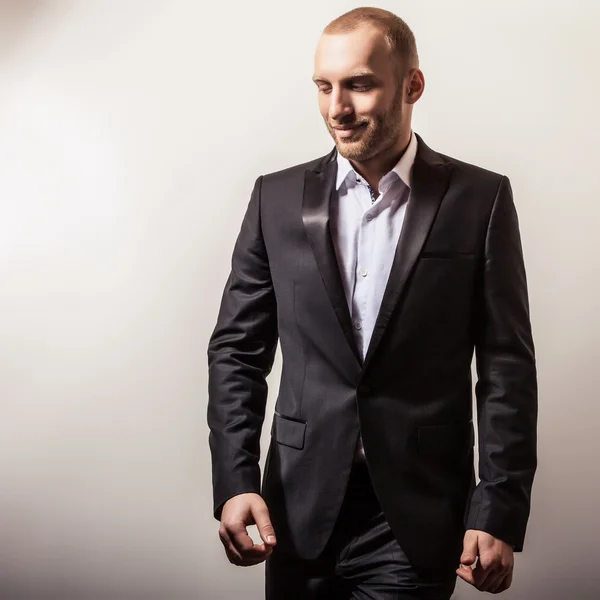 Elegante jovem e bonito homem sorridente vestido de preto. Estúdio retrato de moda . — Fotografia de Stock