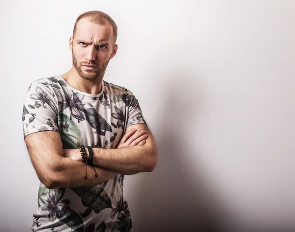 Elégant jeune homme beau en t-shirt coloré lumineux. Portrait de mode studio. beau gosse — Photo