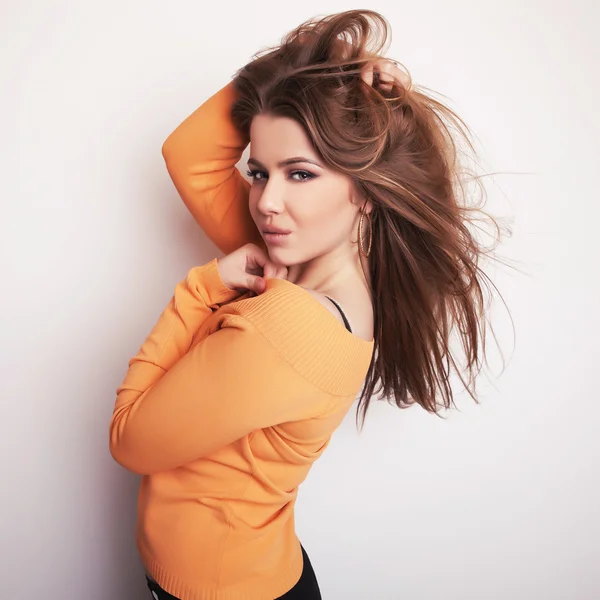 Jovem sensual & beleza modelo menina iin casual laranja suéter pose no estúdio . — Fotografia de Stock