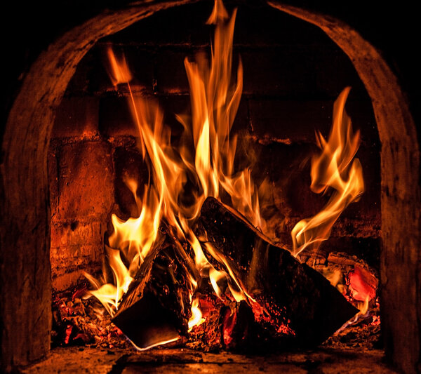 Fireplace with a blazing fire. Photo.