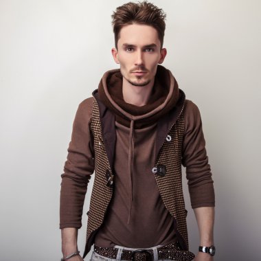 Çekici bir genç adam kahverengi süveter poz Studio.