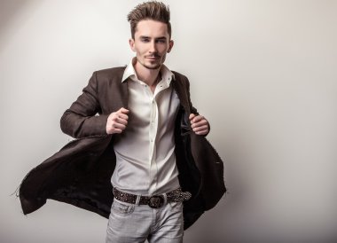 Uzun şık ceket zarif genç yakışıklı adam. Studio moda portre.
