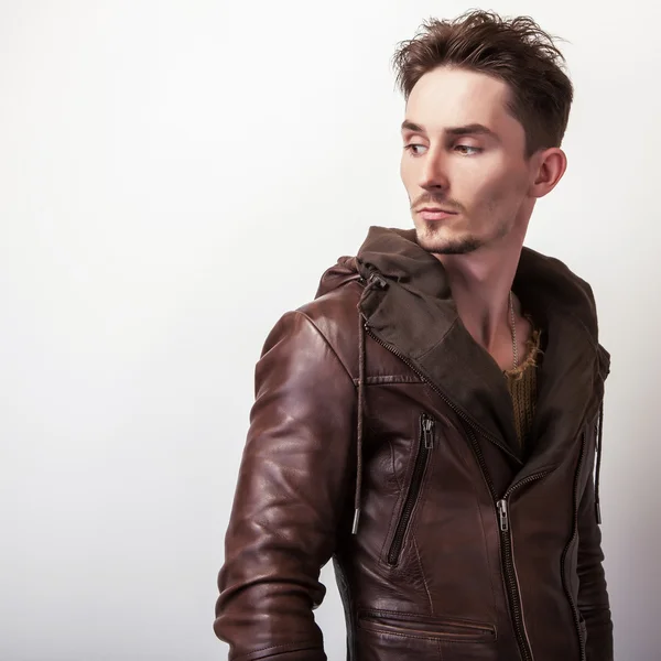 Jovem atraente em uma jaqueta de couro marrom posar em estúdio . — Fotografia de Stock