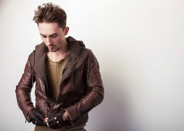 Jeune homme attrayant dans une pose de veste en cuir marron en studio . — Photo