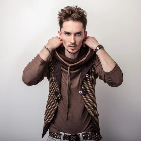 Jeune homme attrayant dans une pose de pull brun en studio . — Photo