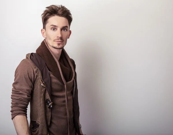 Attractive young man in a brown sweater pose in studio. — Stock Photo, Image