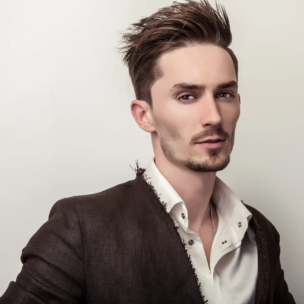 Elégant jeune homme beau en manteau long et élégant. Studio portrait de mode . — Photo