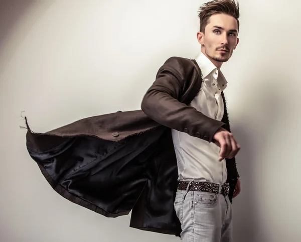 Eleganter junger gutaussehender Mann in langem, stylischem Mantel. Modeporträt im Studio. — Stockfoto