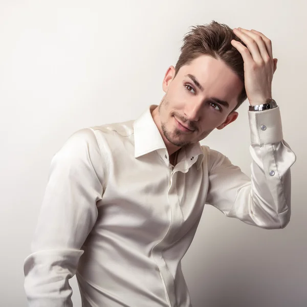 Eleganter junger gutaussehender Mann in weißem Seidenhemd. Modeporträt im Studio. — Stockfoto