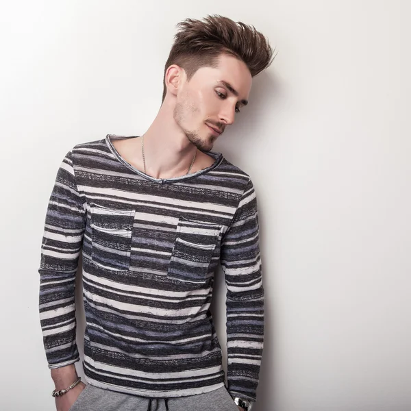 Elegant young handsome man in bright striped gray t-shirt. Studio fashion portrait. — Stock Photo, Image