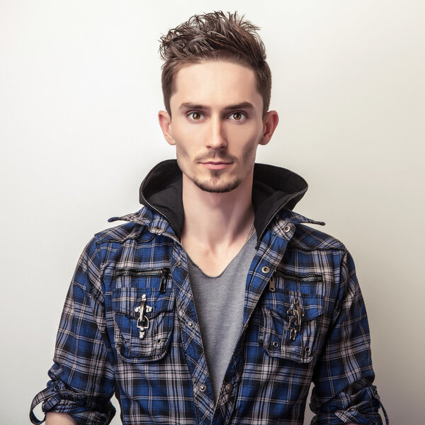 Studio portrait of young handsome man in stylish dark blue jacket.