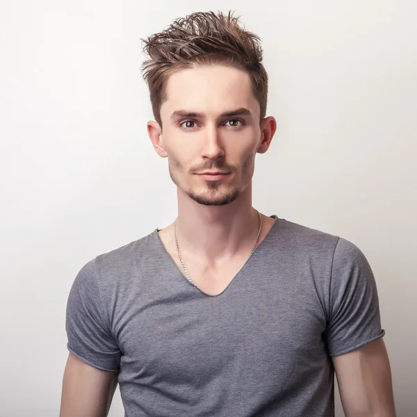 Porträtt av ung vacker man i grå t-shirt. — Stockfoto