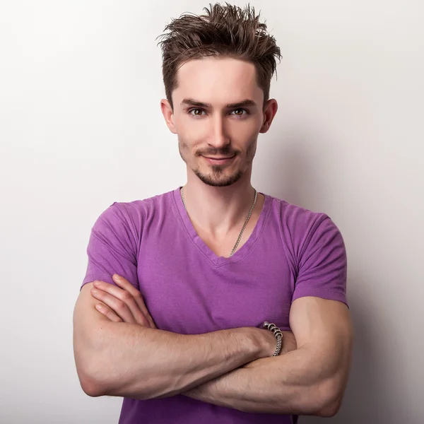 Portrait of young handsome man in violet t-shirt. — Stock Photo, Image