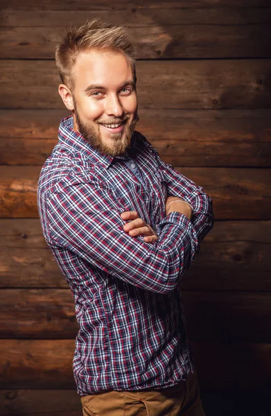 Portrait de jeune bel homme positif contre un vieux mur en bois . — Photo