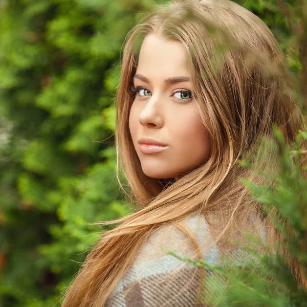 Outdoors portrait of beautiful young girl in casual white sweater & rolled in a plaid. — Stok fotoğraf