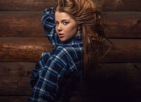 Giovane ragazza attraente in una camicia casual posa su sfondo di legno . — Foto Stock