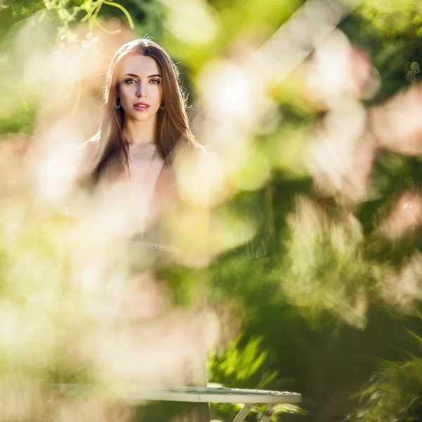 Draußen Porträt der schönen jungen Frau in luxuriösem schwarzen Kleid posiert im Sommergarten. — Stockfoto