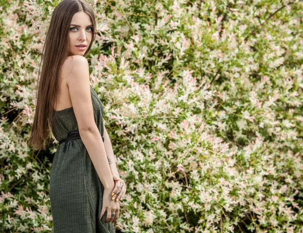 Outdoors portrait of beautiful young woman in fashionable green dress posing in summer garden. — Stock fotografie