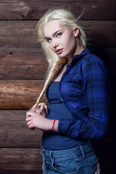 Attractive young blond beauty woman in blue casual shirt pose against wooden background. — Stock Photo, Image