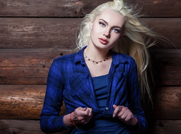 Attrayant jeune femme blonde beauté en bleu casual chemise pose sur fond en bois . — Photo