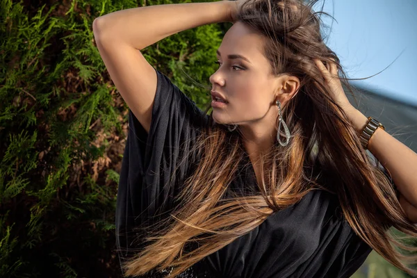 Retrato al aire libre de una hermosa joven en vestido negro largo de lujo posando en el jardín de verano . —  Fotos de Stock