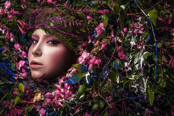 Fairy tale girl portrait surrounded with natural plants and flowers. Art image in bright fantasy stylization. — Stock Photo, Image