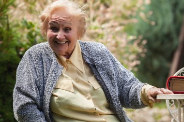 Portrait of smiling old grandmother. Photo on nature background.