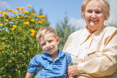 Positive grandmother and grandson spent time together in summer solar garden.