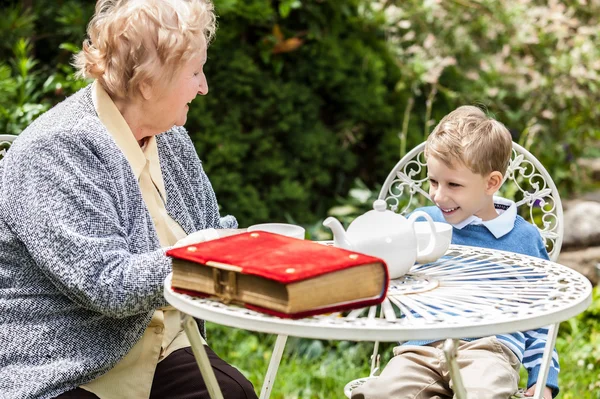 Positive grandmother and grandson spent time together in summer solar garden. — Stockfoto