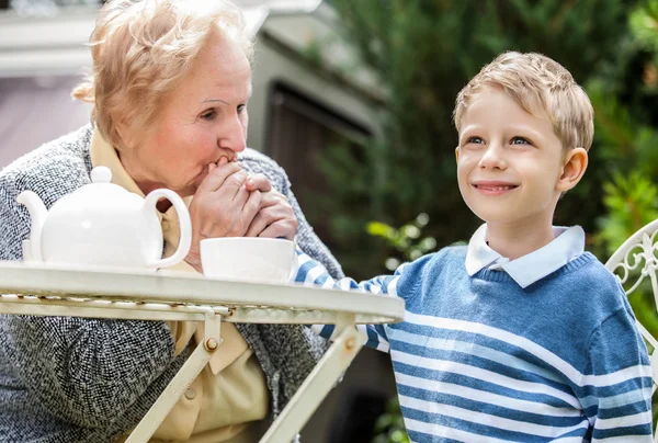 Positive grandmother and grandson spent time together in summer solar garden. — Stock Photo, Image