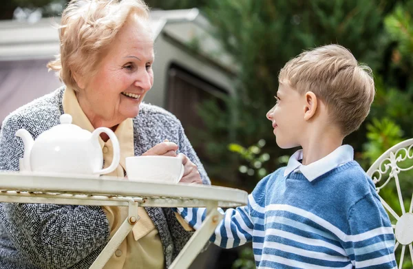 Positive grandmother and grandson spent time together in summer solar garden. — Stock fotografie