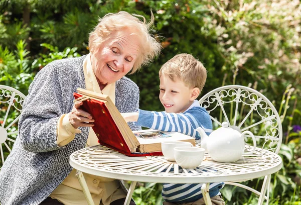 Positive grandmother and grandson spent time together in summer solar garden. — 图库照片