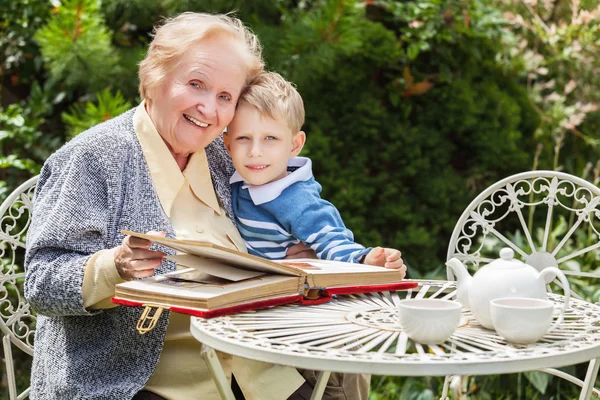 Positive grandmother and grandson spent time together in summer solar garden. — Stock Photo, Image