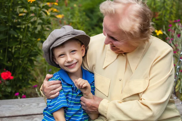 Positive grandmother and grandson spent time together in summer solar garden. — Stockfoto