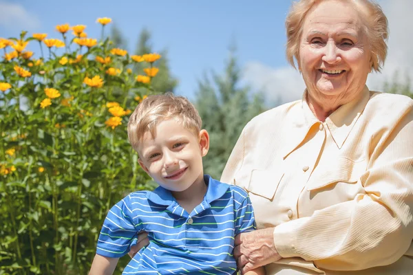 Positive grandmother and grandson spent time together in summer solar garden. — 스톡 사진