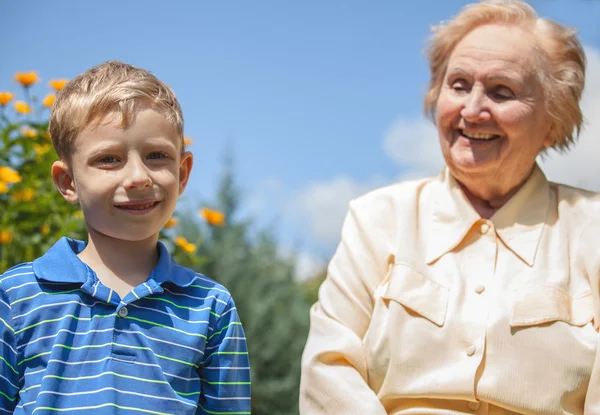 Positive grandmother and grandson spent time together in summer solar garden. — Stockfoto