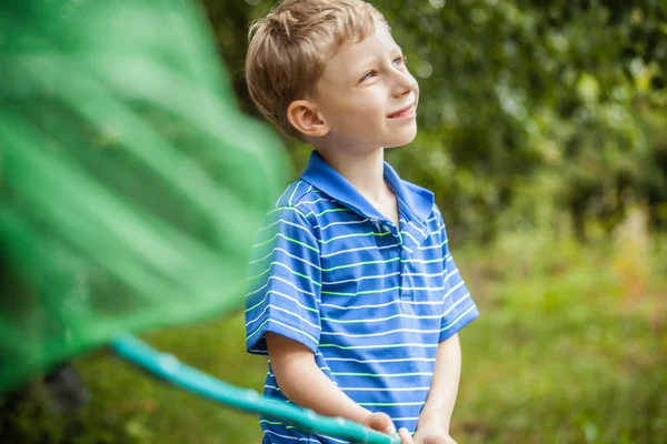 Retrato al aire libre de niño feliz con red para mariposas posando en el jardín de verano . — Foto de Stock