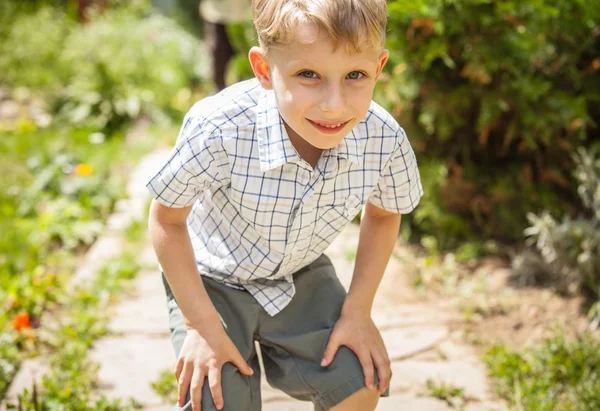 Venkovní portrét pozitivní malého chlapce v slunné letní zahrada. — Stock fotografie