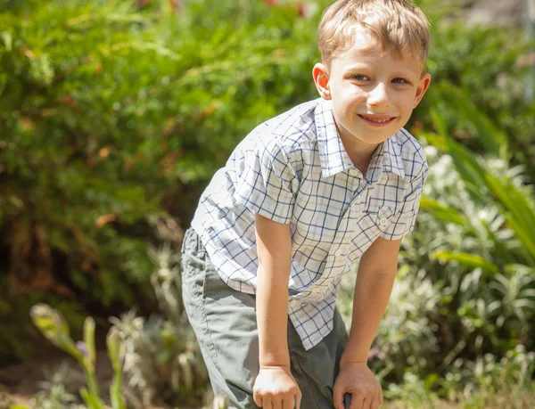 Зовнішній портрет позитивного маленького хлопчика в сонячному літньому саду . — стокове фото