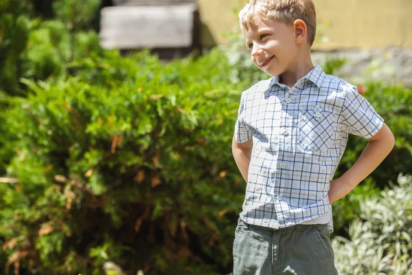 Portrait extérieur de petit garçon positif dans un jardin d'été ensoleillé . — Photo