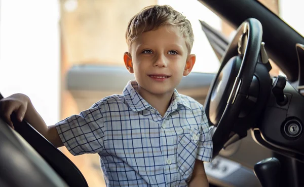 Ritratto all'aperto di bambino biondo felice che esplora salone di auto sportive . — Foto Stock