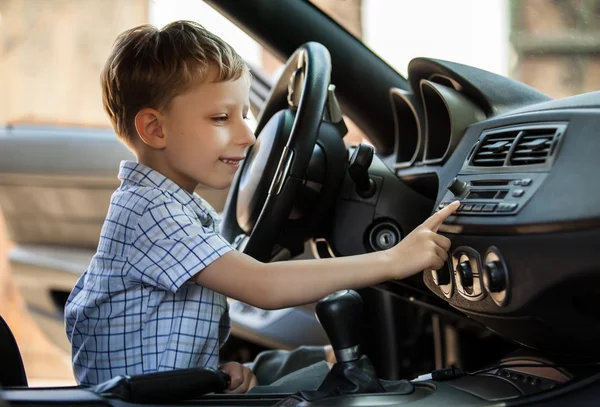 Outdoor portrait of happy blond little boy who explore salon of sport auto. — Stock Photo, Image