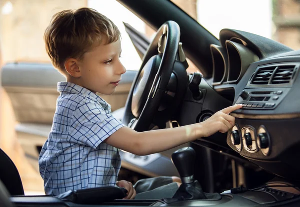 Outdoor portrait of happy blond little boy who explore salon of sport auto. — Stock Photo, Image