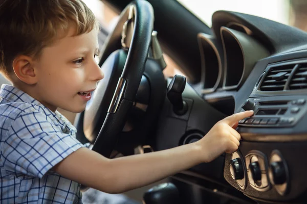 Outdoor portrait of happy blond little boy who explore salon of sport auto. — Stock Photo, Image