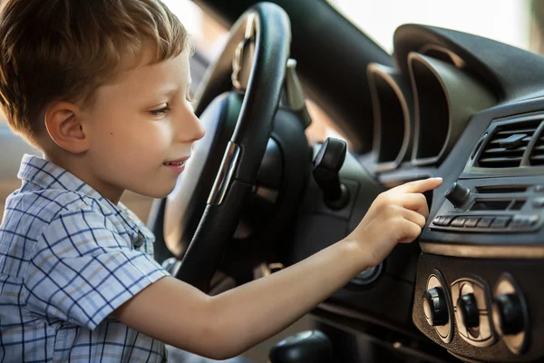 Outdoor portrait of happy blond little boy who explore salon of sport auto. — Stock Photo, Image