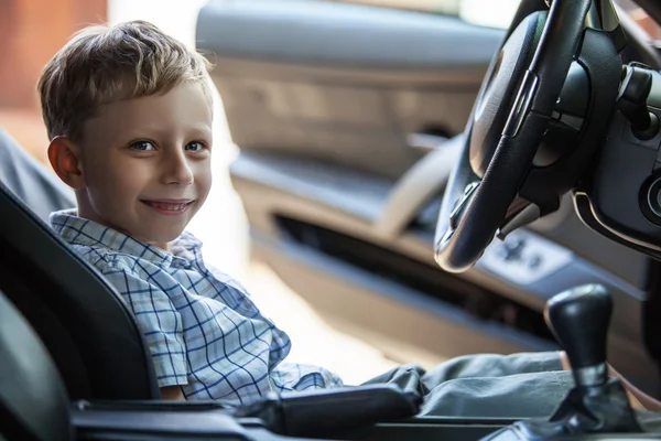 Ritratto all'aperto di bambino biondo felice che esplora salone di auto sportive . — Foto Stock